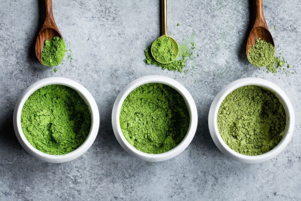 Three bowls of matcha powder in different shades of green with wooden spoons, showing how to choose matcha quality