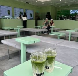 Matcha beverage shop interior with mint green tables and two iced green drinks